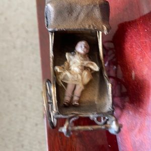VINTAGE BISQUE SMALLEST DOLL WITH VINTAGE CARRiEGE. Doll IS JOINTED. FROM 1800’s
